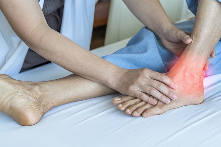 Patient mit Fußschmerzen bei einer Untersuchung. Wenn dem Körper wichtige Nährstoffe fehlen, können Krankheiten wie Osteoporose oder Arthrose bereits in jungen Jahren auftreten.