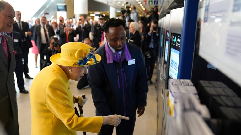 Queen Elizabeth am Fahrkartenautomat: Ein Mitarbeiter zeigt der Königin, wie man ein Ticket kauft.
