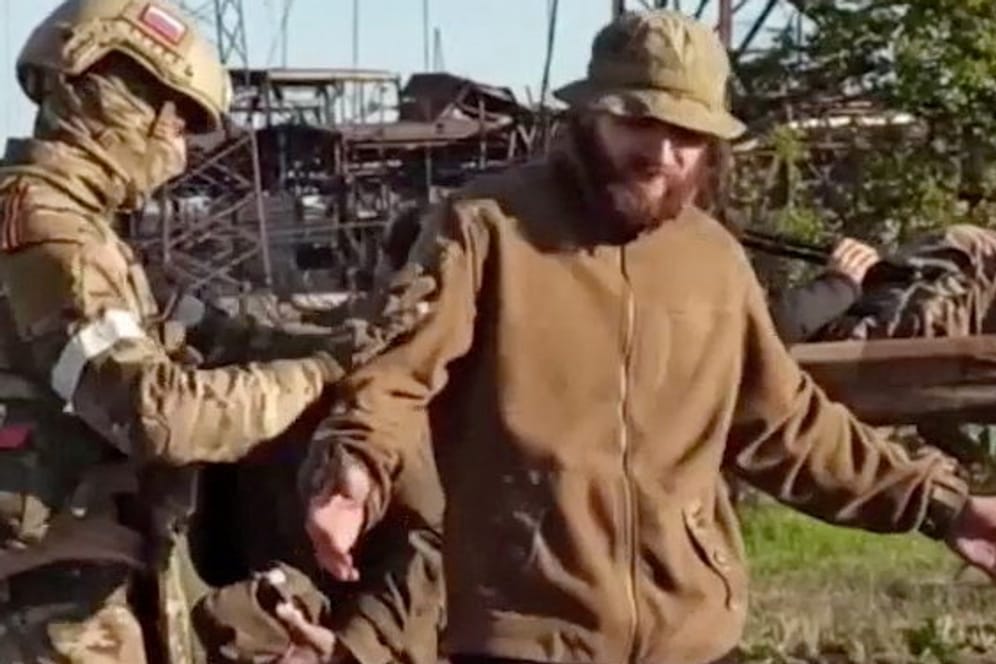 Russischer Soldat durchsucht ukrainischen Soldaten in Mariupol: "Die Verteidiger von Mariupol haben der Ukraine dringend benötigte Zeit verschafft".