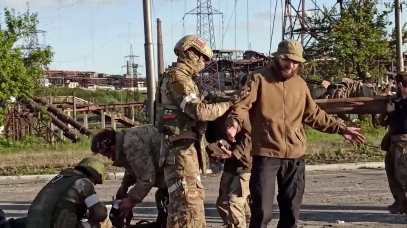 Russische Soldaten durchsuchen einen ukrainischen Kämpfer aus dem Asowstal-Stahlwerk.