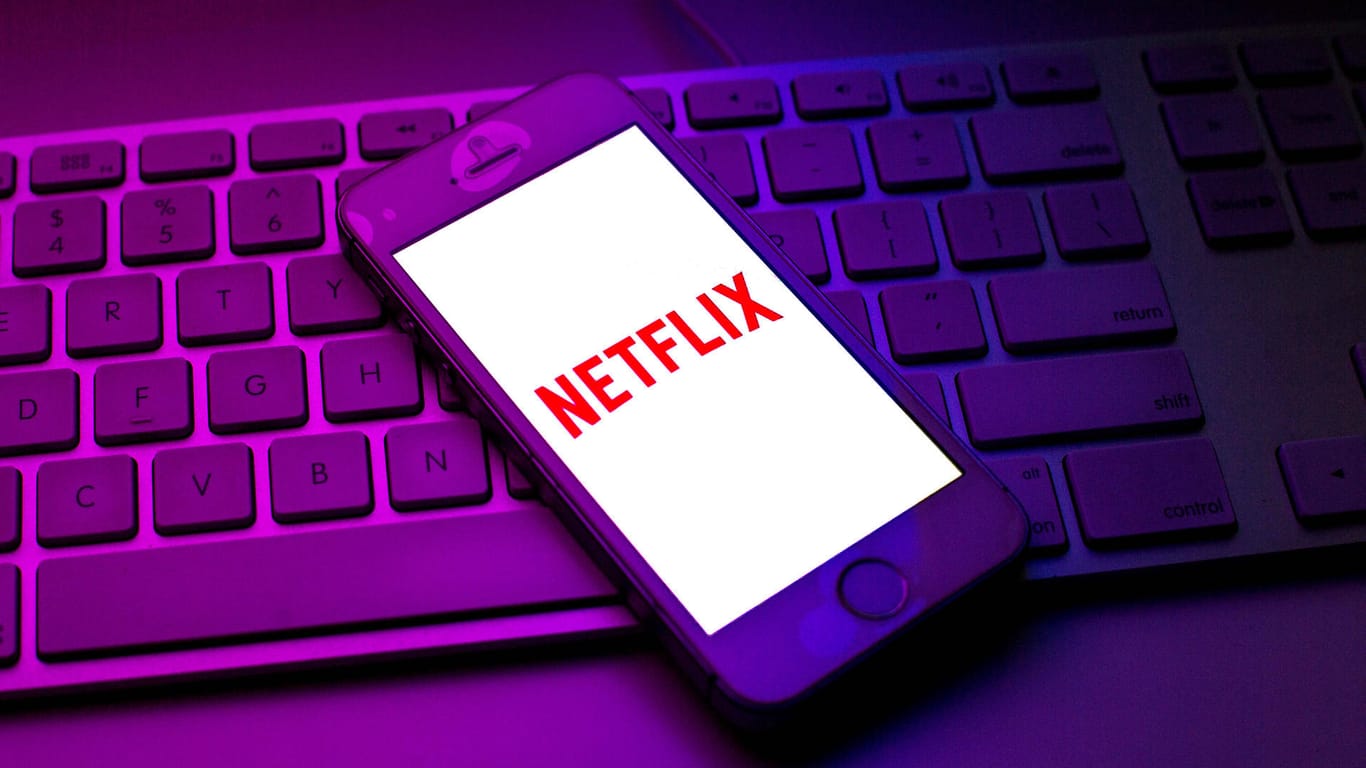 Eine Person vor einer Bildschirmwand mit dem Netflix-Logo (Symbolbild): Netflix kämpft mit sinkenden Abozahlen und einer wachsenden Konkurrenz.