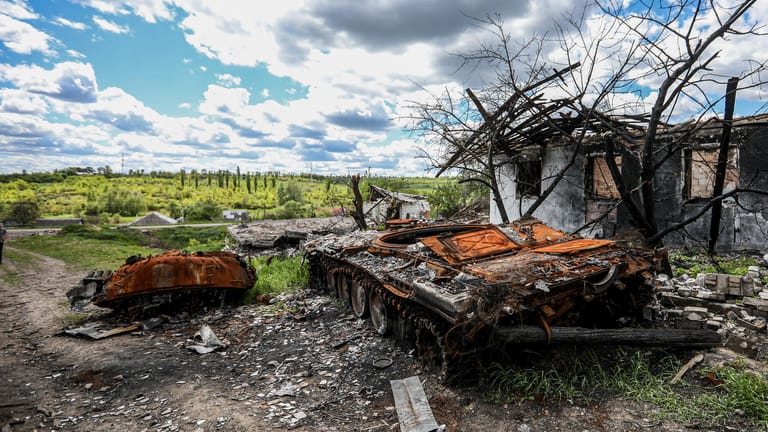 Ein ausgebrannter russischer Panzer vor einem zerstörten Wohnhaus in dem Dorf Mala Rogan, östlich von Charkiw: Russland gestand nun ein, dass es Schwierigkeiten in der sogenannten Spezialoperation gebe.