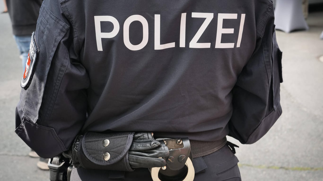 Handschellen am Gürtel einer Polizeibeamtin (Symbolbild): Nach einem gewalttätigen Streit in München wurde ein Tatverdächtiger festgenommen.
