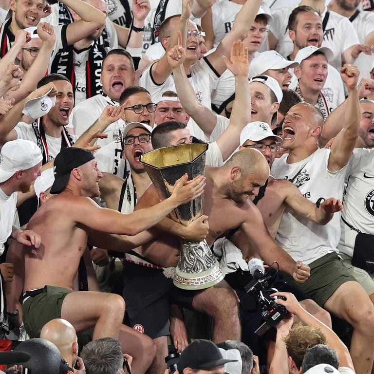 Die Frankfurter Fans mit dem Pokal: Zwei von ihnen stürzten beim Torjubel zum 1:1 ab und mussten behandelt werden.
