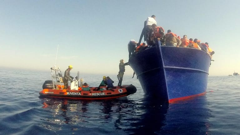 Ein Schlauchboot der Iuventa neben einem Flüchtlingskahn (Archivbild): Die freiwilligen Helfer nutzen ihren Urlaub, um Menschen auf dem Mittelmeer zu retten.