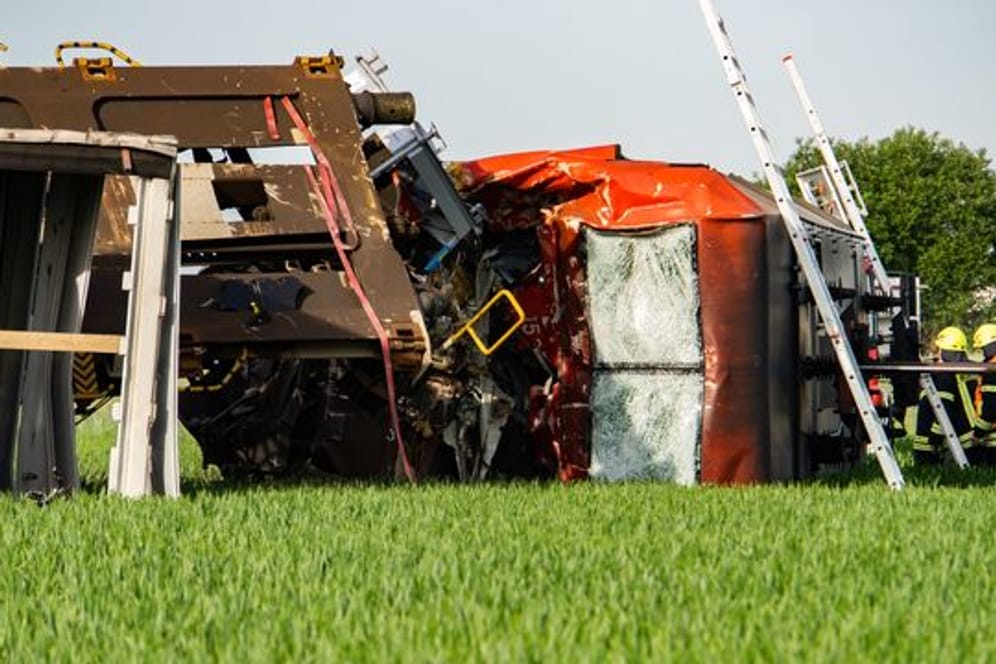 Eine Lok liegt neben den Gleisen auf einem Feld: Bei einem Unfall mit zwei Güterzügen in Südhessen ist ein Lokführer ums Leben gekommen.