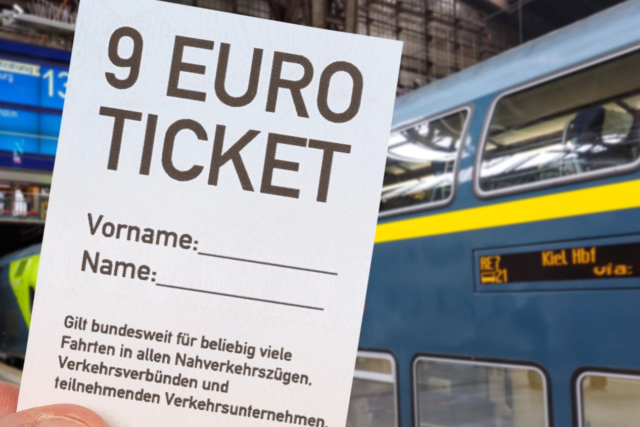 Eine Hand hält ein weißes 9-Euro-Ticket hoch (Symbolbild): Für drei Monate können Bürger alle Züge und Busse im Regional- und Nahverkehr nutzen.