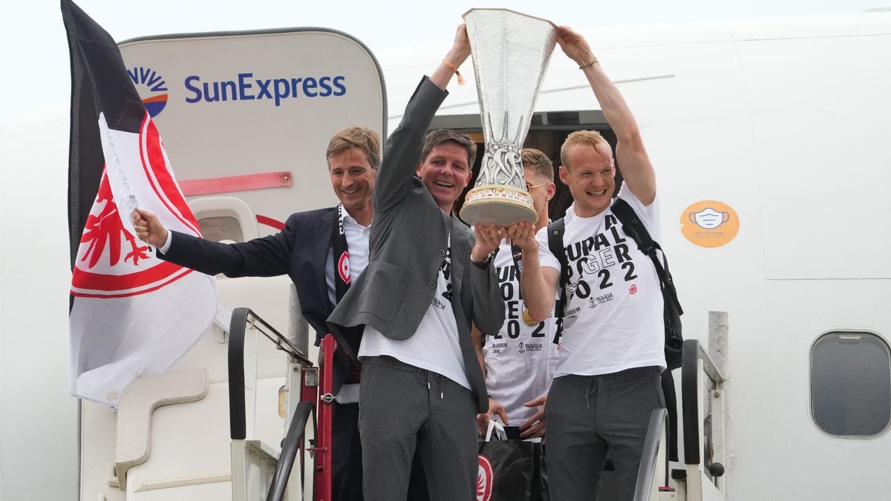 Da ist der Pott: Eintracht-Coach Oliver Glasner (l) und Kapitän Sebastian Rode präsentieren den Europa-Pokal nach der Landung. Da ist der Pott: Eintracht-Coach Oliver Glasner (l) und Kapitän Sebastian Rode präsentieren den Europa-Pokal nach der Landung.
