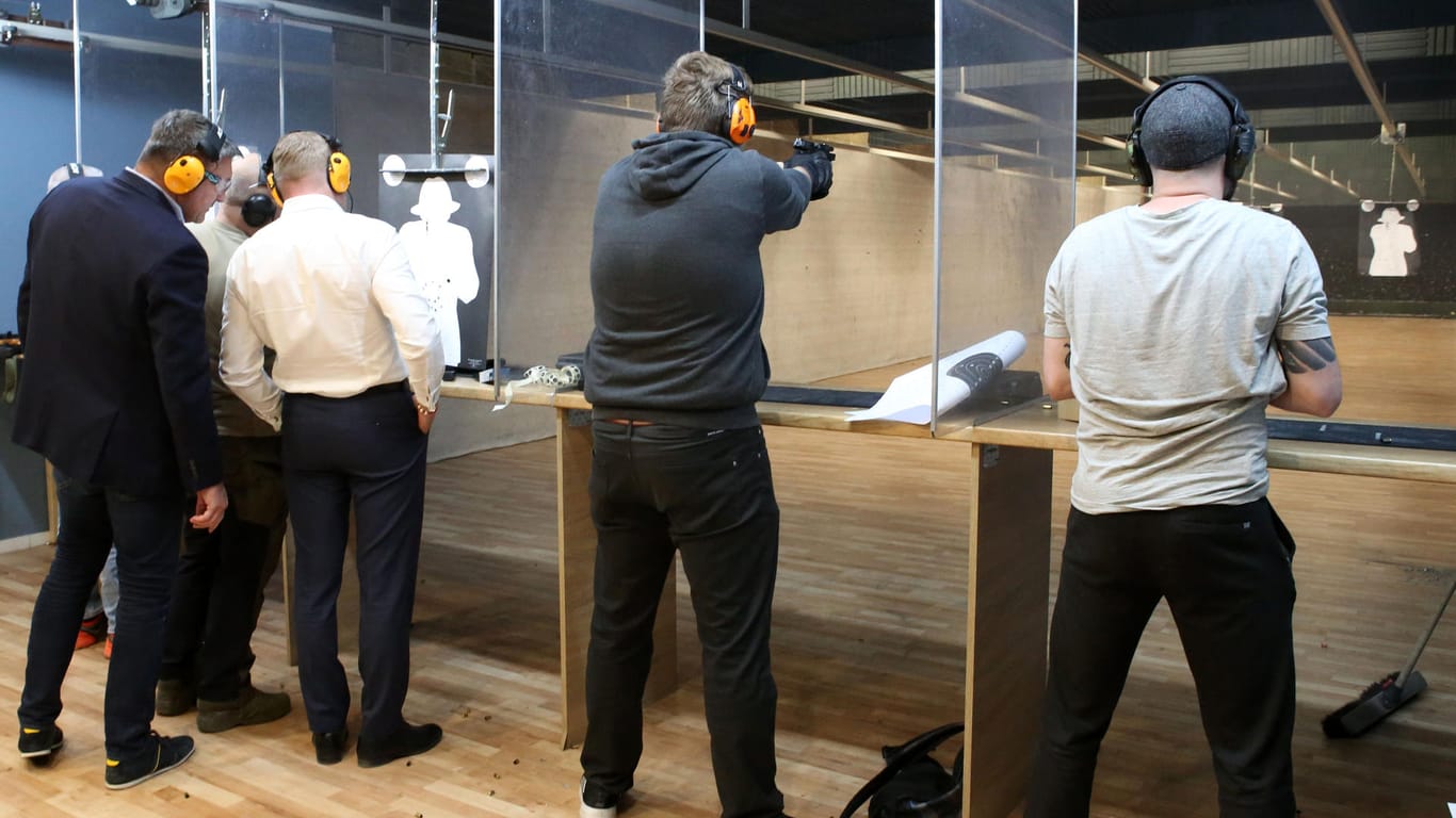 Teilnehmer eines Schießkurses stehen mit einem Gewehr in der Hand an einem Schießstand in Polen.