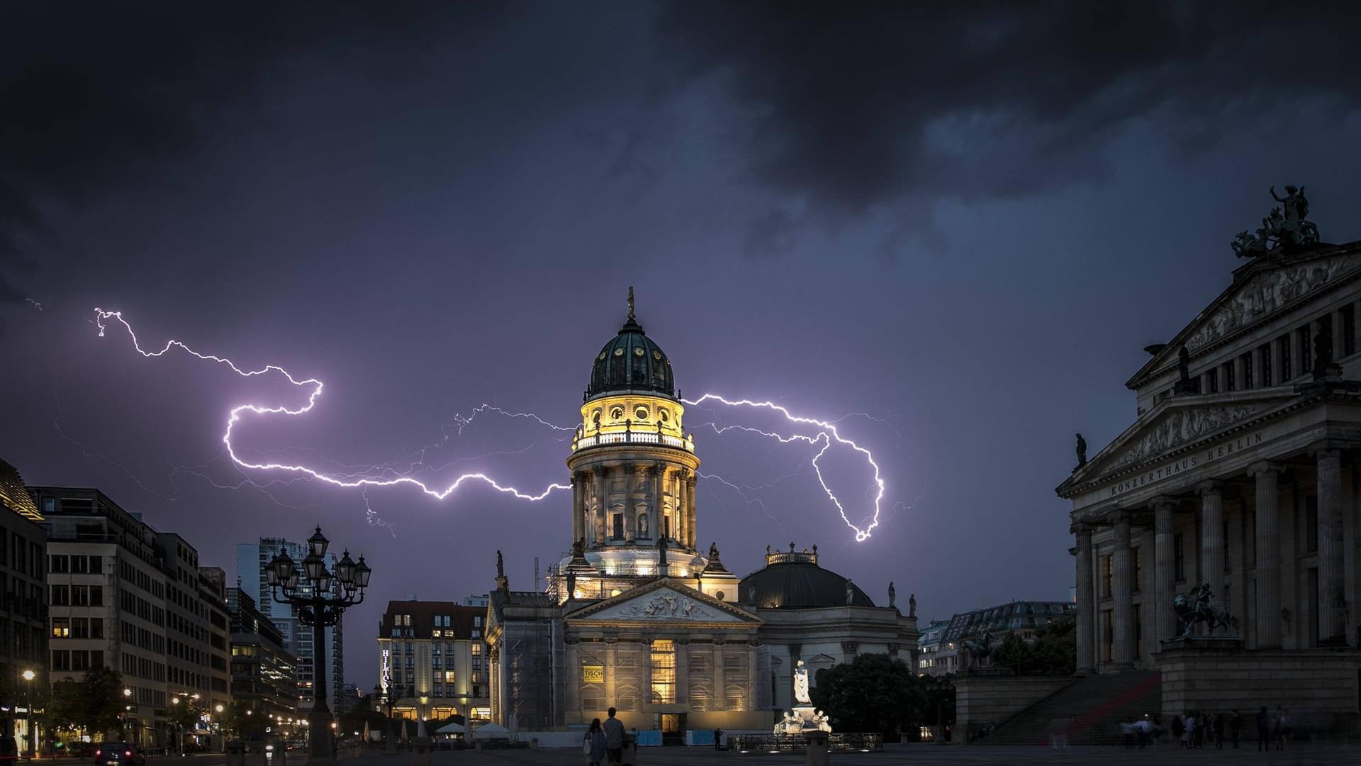 Blitze über dem Berliner Konzerthaus und dem Deutschen Dom (Archivbild): In der Hauptstadt könnten sich am Freitag Tornados bilden.