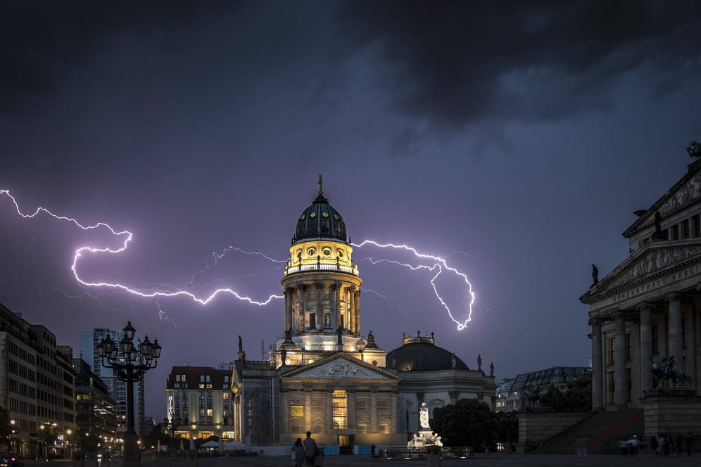 Blitze über dem Berliner Konzerthaus und dem Deutschen Dom (Archivbild): In der Hauptstadt könnten sich am Freitag Tornados bilden.