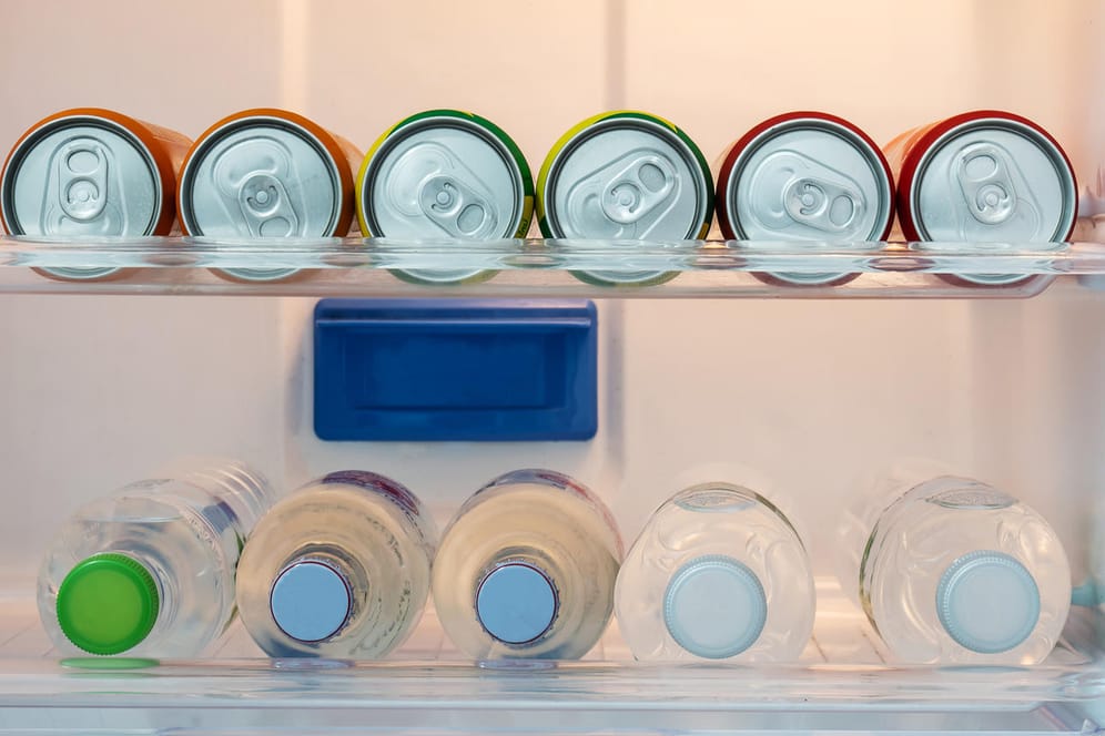 Colorful Soft drink cans and cold soda or mineral water inside the fridge in hotel room.