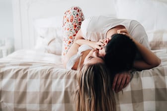 Küssendes Paar im Bett