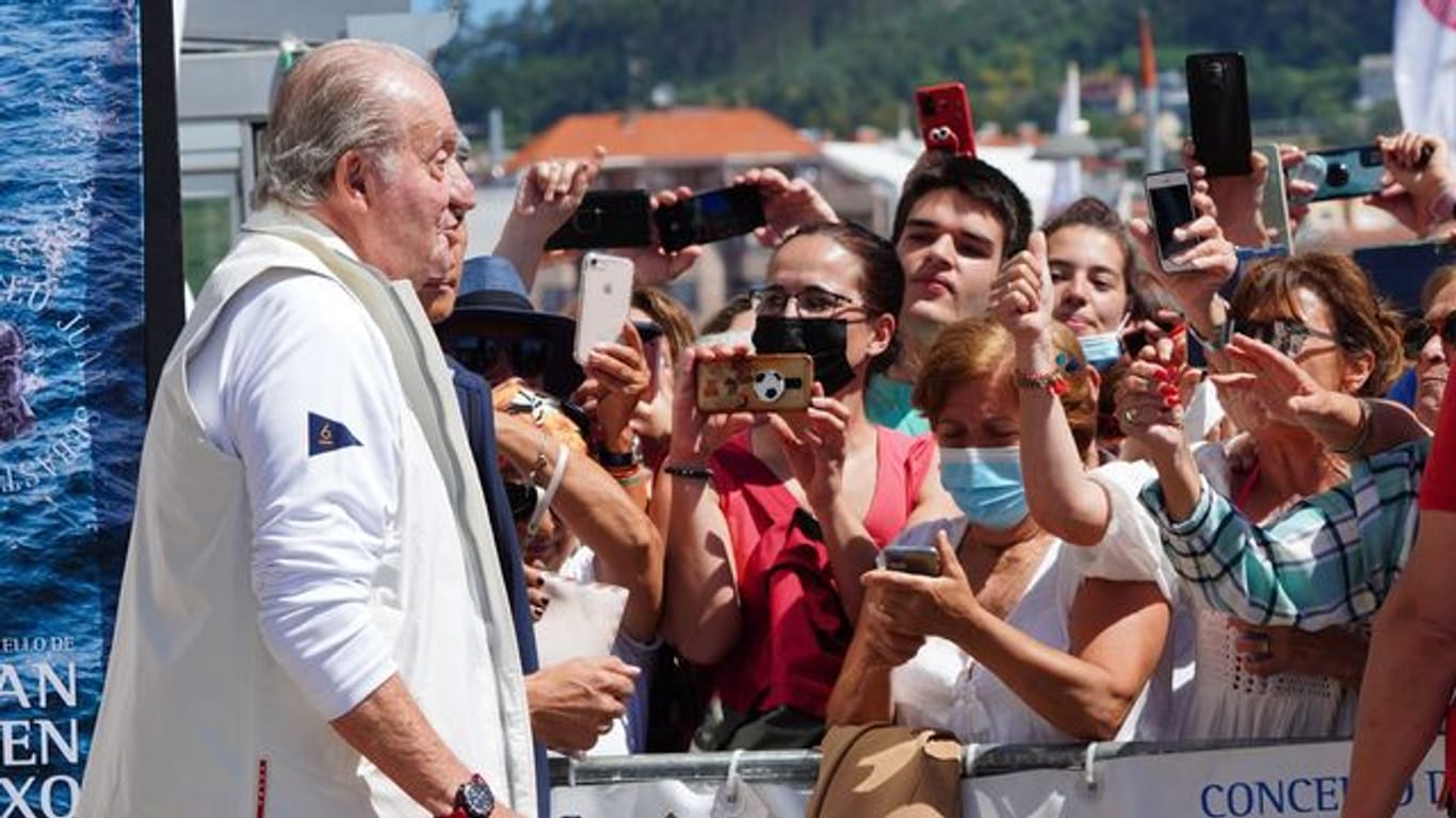 Juan Carlos (l), Altkönig von Spanien, spricht mit Schaulustigen vor einem Empfang in einem Nautikclub vor einer Segelveranstaltung in Sanxenxo.