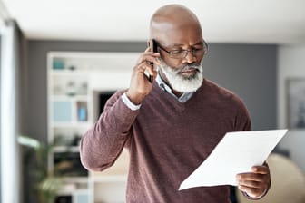 Älterer Mann beim Telefonieren (Symbolbild): Eine Riesterrente ist eine Einnahme aus einem Altersvorsorgevertrag.