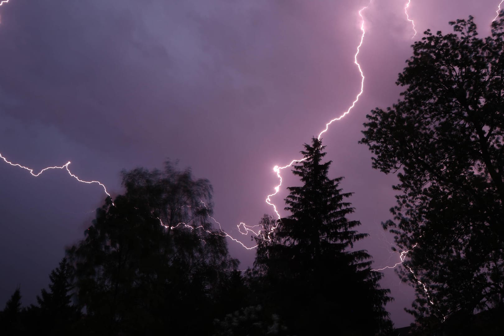 Ein Blitzeinschlag und Gewitterwolken (Symbolbild): Auch am Samstag und Sonntag ist mit Schauern zu rechnen.