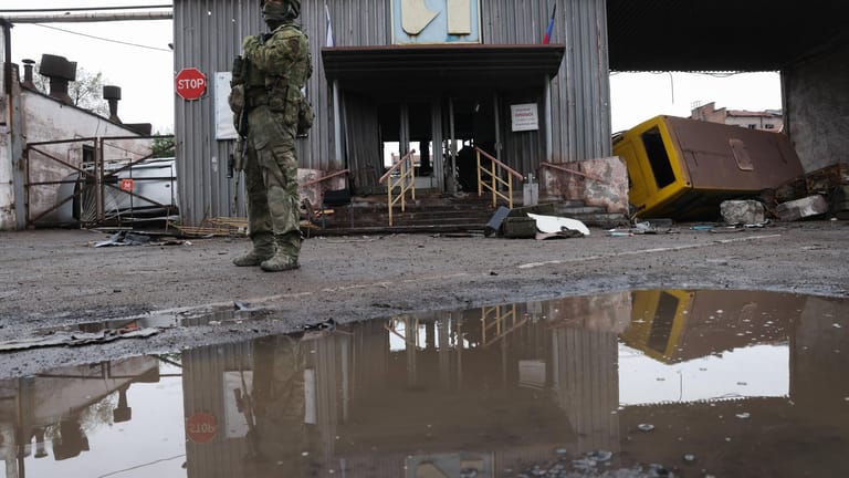 Ein russischer Soldat steht vor einem Stahlwerk in Mariupol (Archivbild): Die Stadt ist jetzt offenbar komplett unter russischer Kontrolle.
