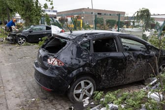 Paderborn: Blick auf zerstörte Autos an einer Straße. Ein Tornado hat in Paderborn und Lippstadt am Freitagnachmittag massive Schäden verursacht.