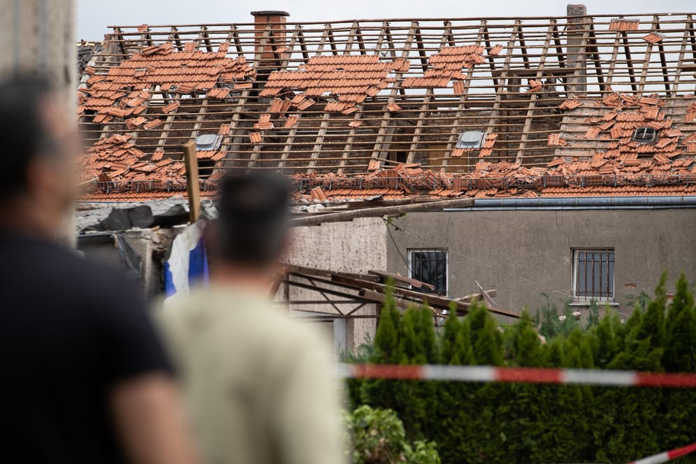 Paderborn: Anwohner blicken auf das beschädigte Dach eines Hauses.
