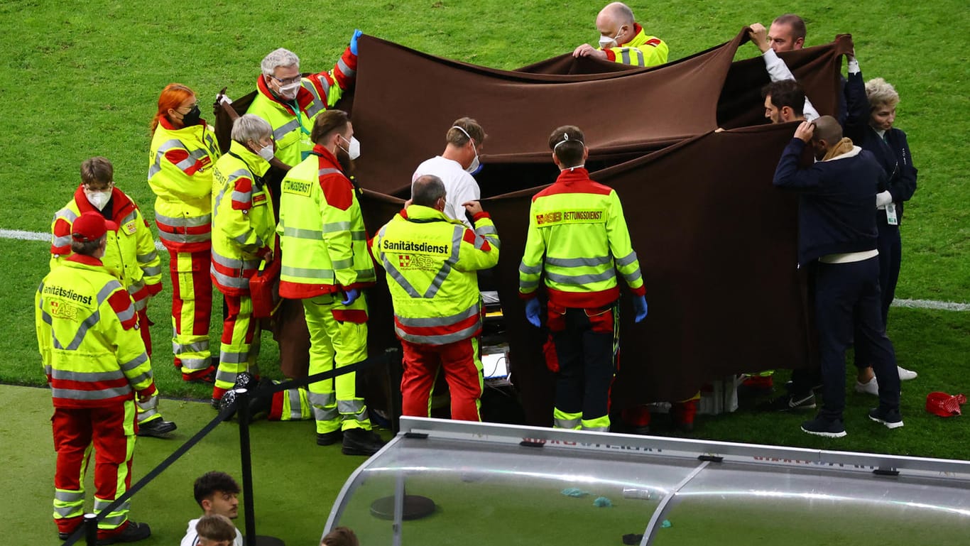 Sanitäter behandeln einen zusammengebrochenen Fotografen: Die Menge im Stadion verstummte wenige Sekunden später.
