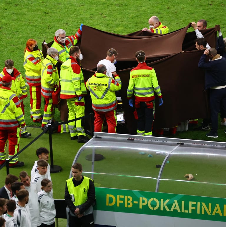 Sanitäter behandeln einen zusammengebrochenen Fotografen: Die Menge im Stadion verstummte wenige Sekunden später.