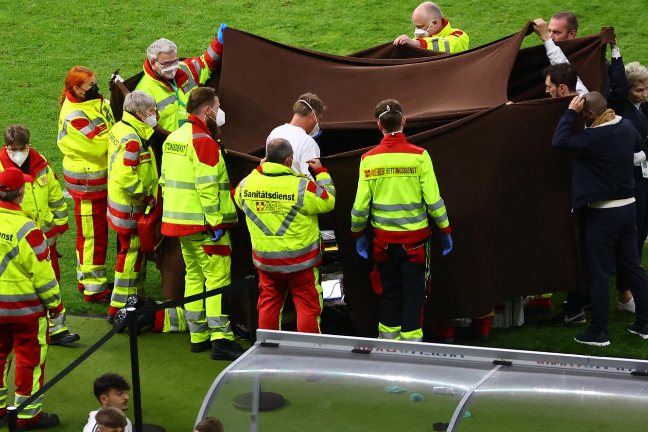 Sanitäter behandeln einen zusammengebrochenen Fotografen: Die Menge im Stadion verstummte wenige Sekunden später.