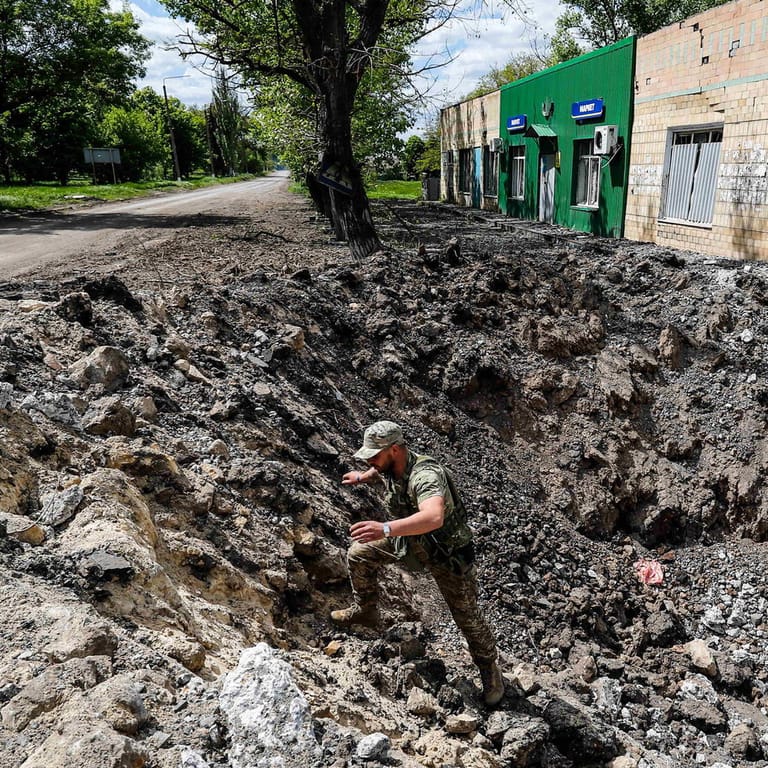 Ein ukrainischer Soldat einer Aufklärungseinheit begutachtet ein riesiges Loch, das durch einen russischen Luftangriff am Rande der Donbass-Region entstanden sein soll