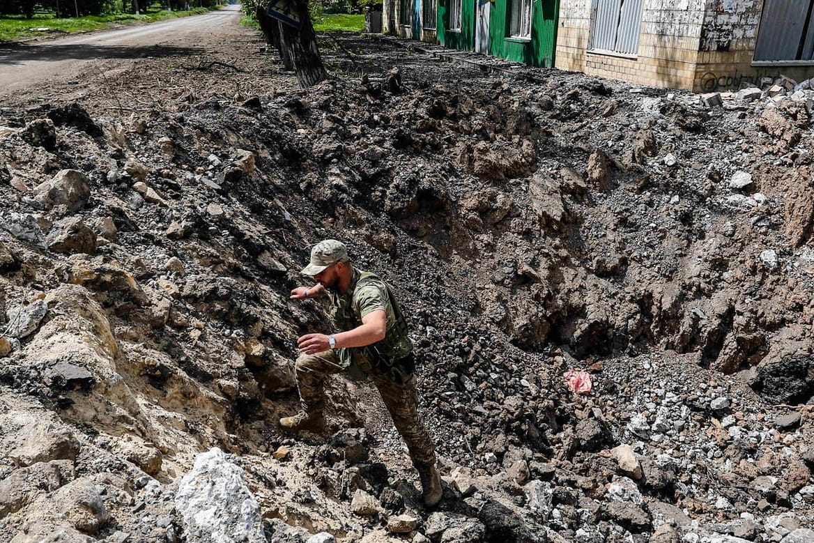 Ein ukrainischer Soldat einer Aufklärungseinheit begutachtet ein riesiges Loch, das durch einen russischen Luftangriff am Rande der Donbass-Region entstanden sein soll