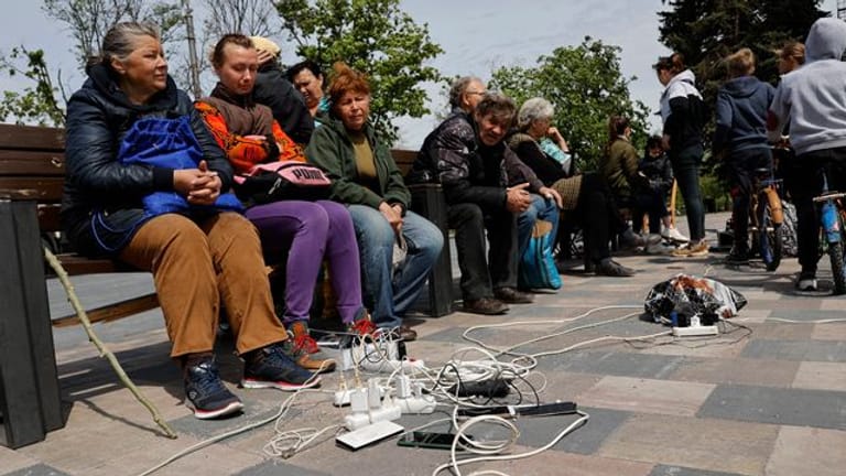 Menschen in Mariupol laden ihre Telefone auf - das Gebiet in der Ostukraine steht unter der Regierung der sogenannten Donezker Volksrepublik.