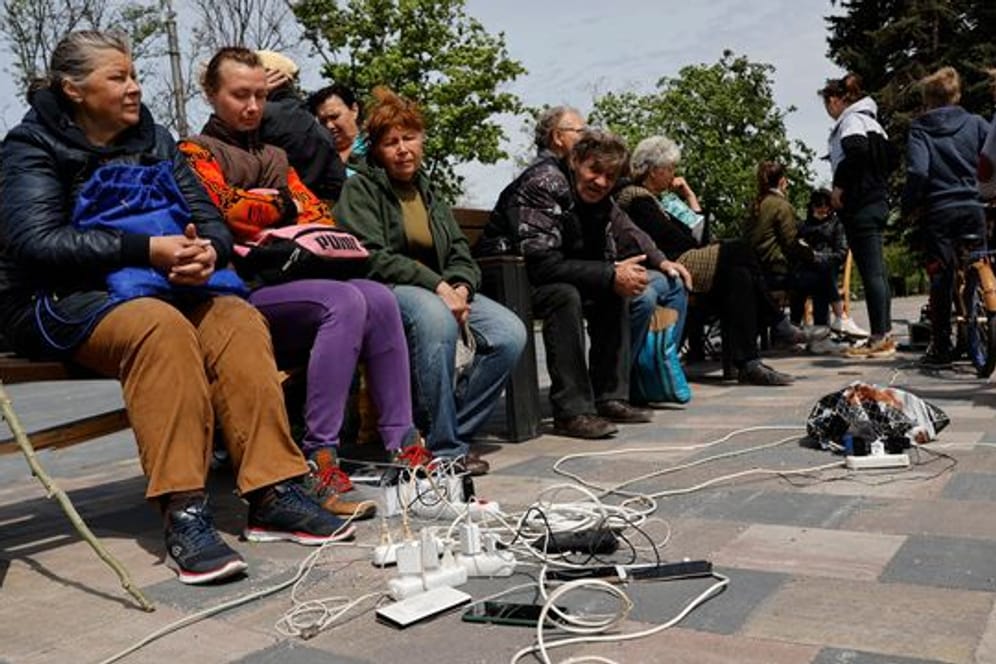 Menschen in Mariupol laden ihre Telefone auf - das Gebiet in der Ostukraine steht unter der Regierung der sogenannten Donezker Volksrepublik.
