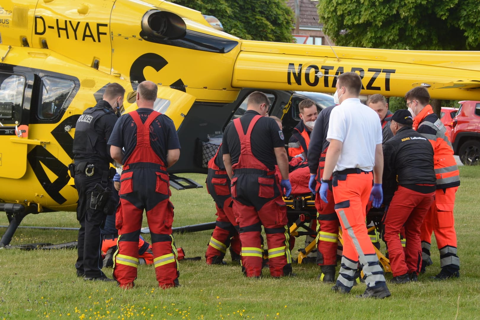 Rettungskräfte bringen den Mann zu einem Rettungshubschrauber.