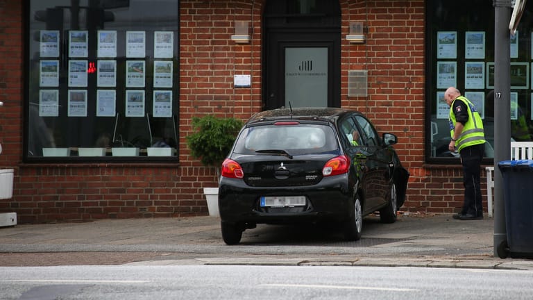 Ein Polizist am Unfallort: In Hummelsbüttel ist ein Mann mit seinem Wagen gegen eine Hauswand gefahren.