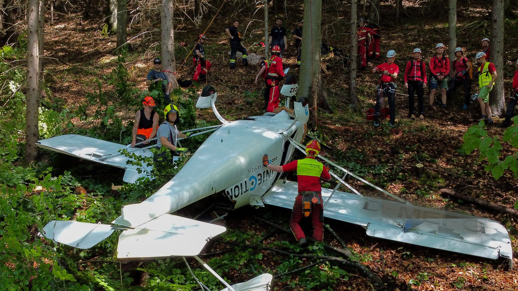 Feuerwehrleute sind neben einem der abgestürzten Flugzeuge im Einsatz. Zwei bayerische Piloten sind bei einem gemeinsamen Flug mit ihren Leichtflugzeugen in Österreich zusammengestoßen. Feuerwehrleute sind neben einem der abgestürzten Flugzeuge im Einsatz. Zwei bayerische Piloten sind bei einem gemeinsamen Flug mit ihren Leichtflugzeugen in Österreich zusammengestoßen.