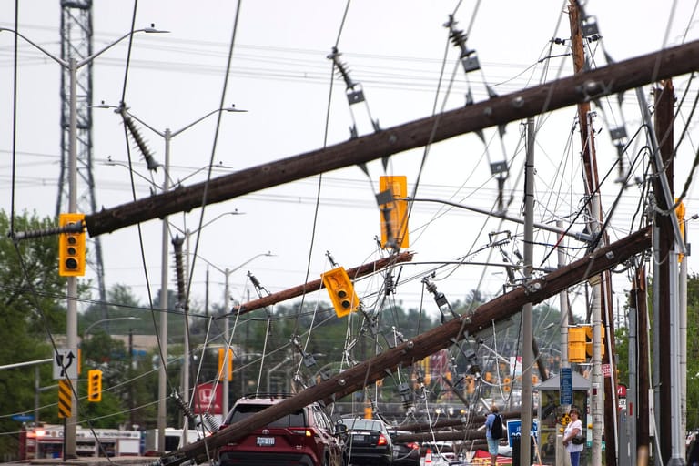 Kanada, Ottawa: Ein Fahrzeug steht nach einem schweren Sturm auf der Merivale Road zwischen umgestürzten Stromleitungen und Versorgungsmasten.