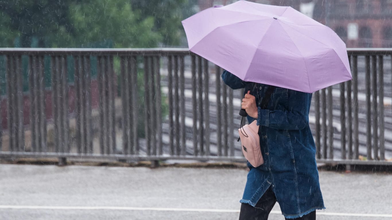 Eine Frau mit Regenschirm (Symbolbild): Auch am Montag gilt eine Unwetterwarnung für Nürnberg und Mittelfranken.