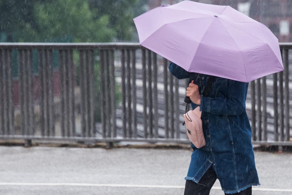 Eine Frau mit Regenschirm (Symbolbild): Auch am Montag gilt eine Unwetterwarnung für Nürnberg und Mittelfranken.