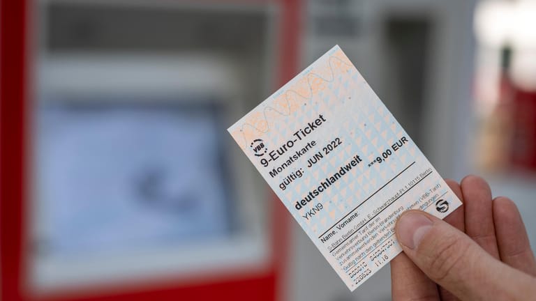 Eine Person hält ein 9-Euro-Ticket in der Hand (Symbolbild).
