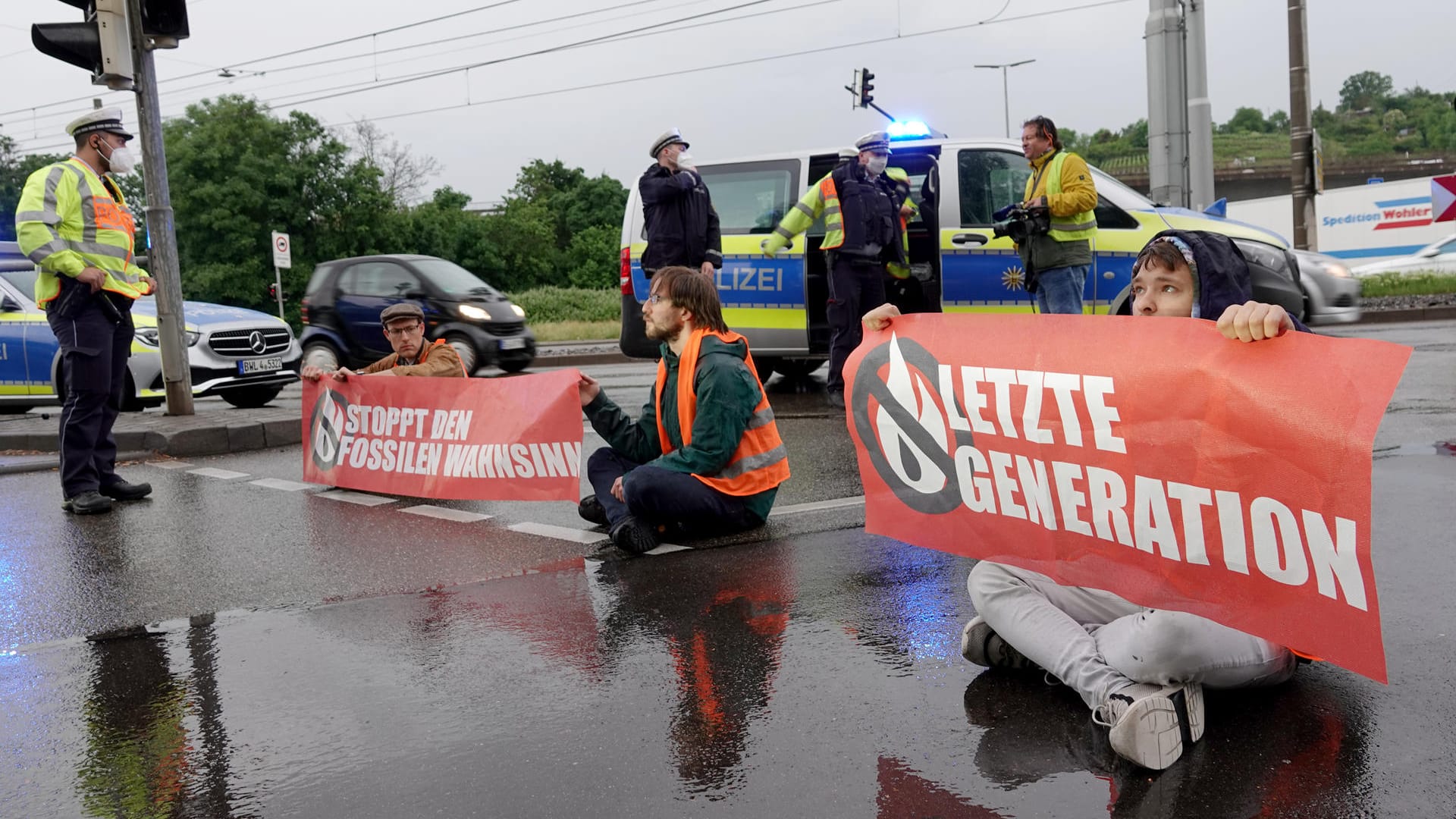 Aktivisten sitzen mit Protestplakaten auf der Straße: Weitere Blockaden sind bereits angekündigt.