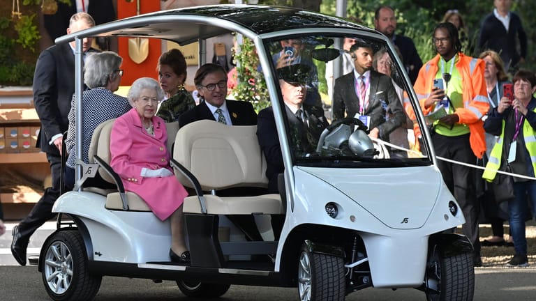 Die Queen wird mit einem Golf-Buggy über das Gelände gefahren.