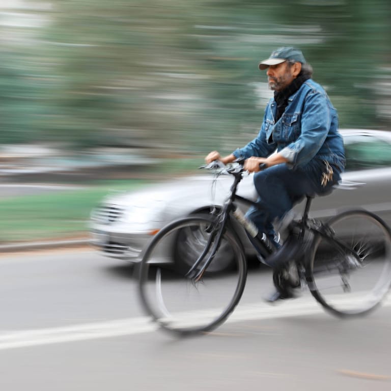 Ein Fahrradfahrer überholt ein Auto (Symbolbild): Vor allem am Vatertag häufen sich Unfälle mit alkoholisierten Radfahrern.