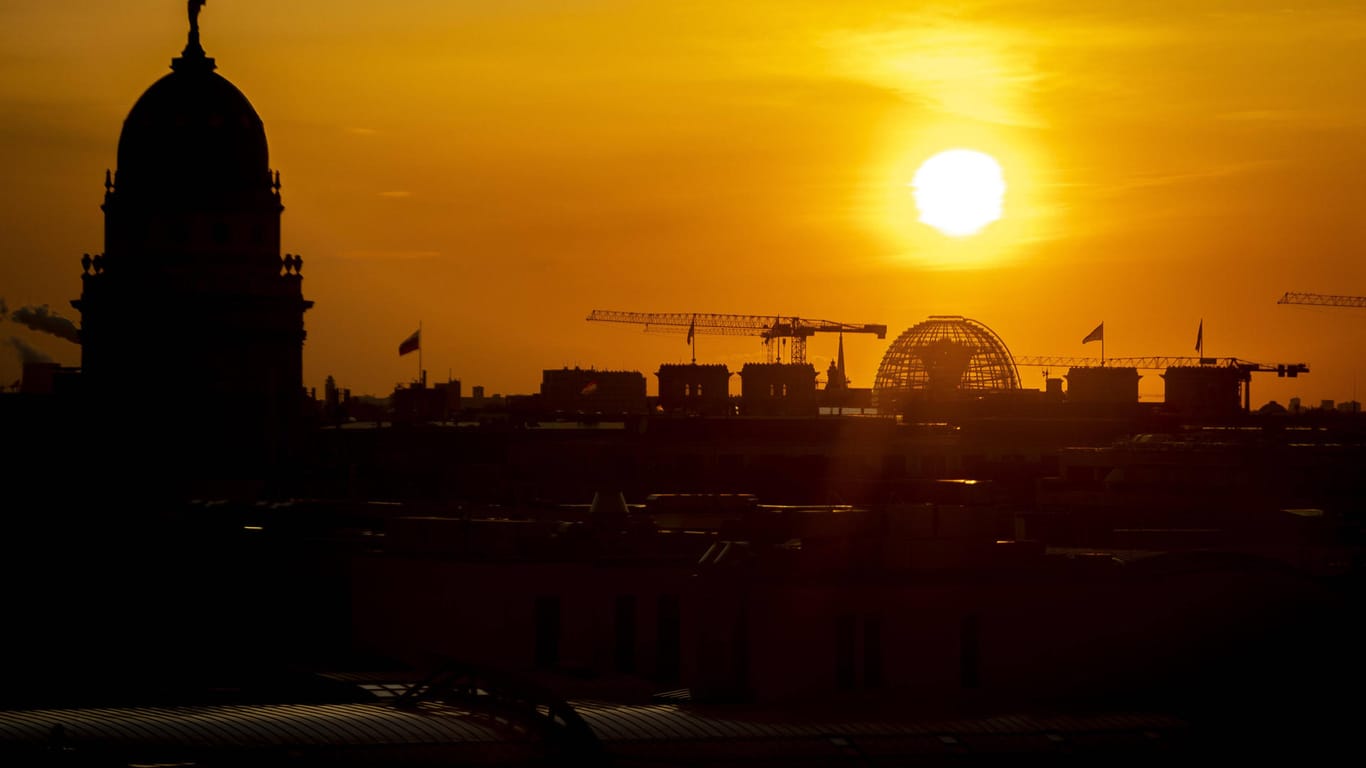Die Sonne geht hinter dem Reichstagsgebäude unter (Archivbild): Im Sommer lassen sich in Berlin besonders schöne Sonnenuntergänge beobachten.