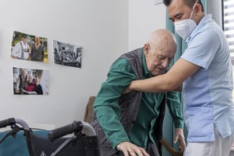 Pfleger hilft altem Mann (Symbolbild): Die Beiträge in der Pflegeversicherung müssen sich ändern.