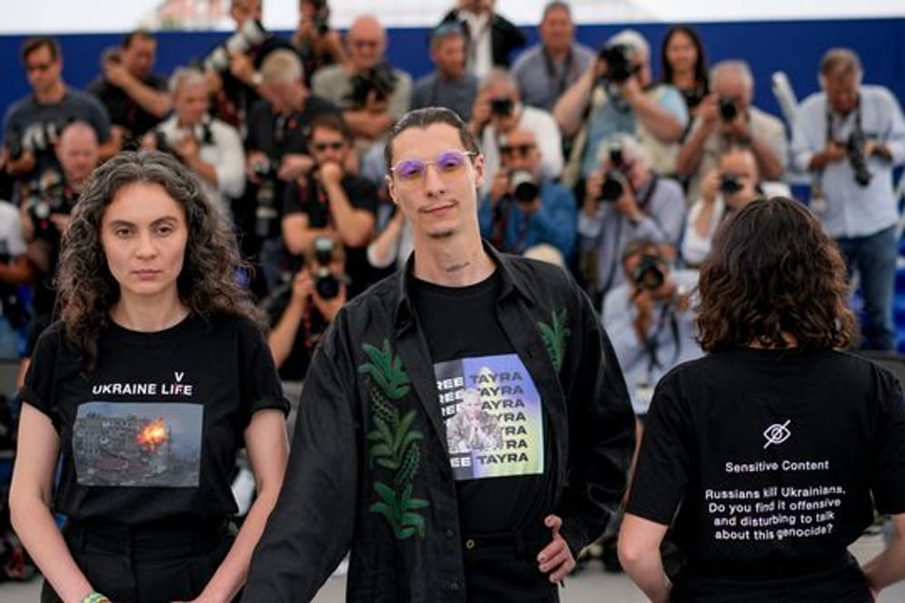 Darya Bassel (l), Maksym Nakonechnyi (M) und Yelizaveta Smith (r) auf dem roten Teppich in Cannes.