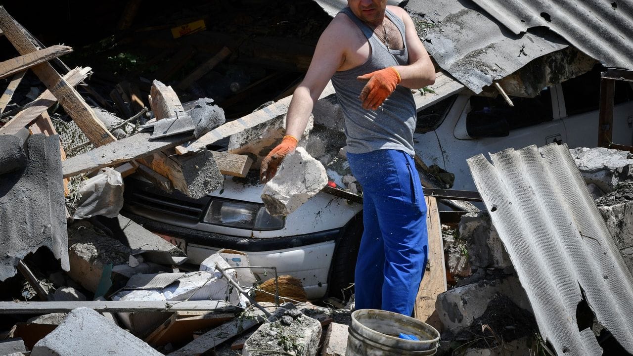 Ein Bewohner entfernt nach russischem Beschuss Trümmer eines zerstörten Hauses in der Stadt Kramatorsk.