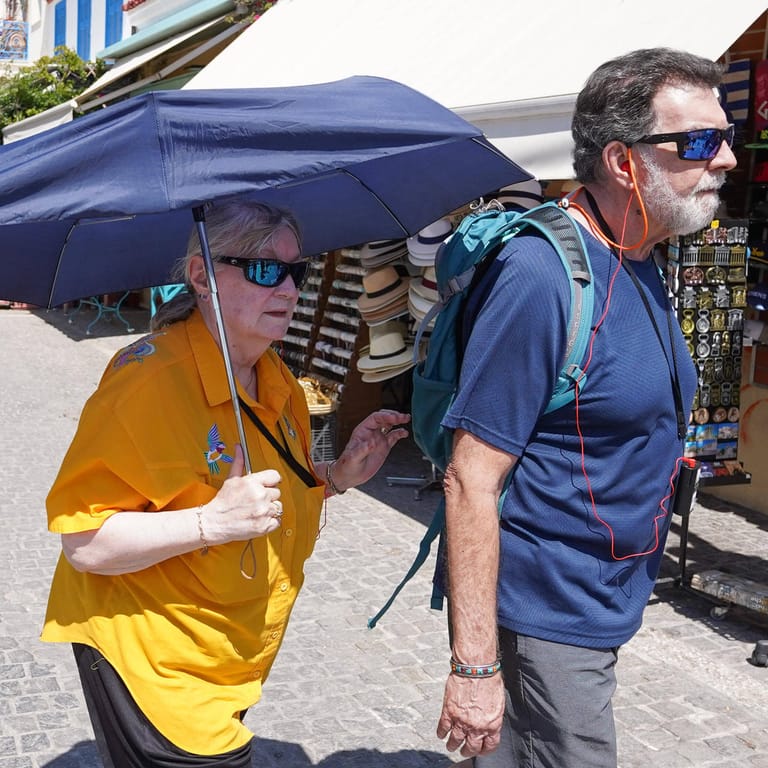 Touristen mit Sonnenschirm in Athen: In den kommenden Tagen soll es besonders heiß werden.