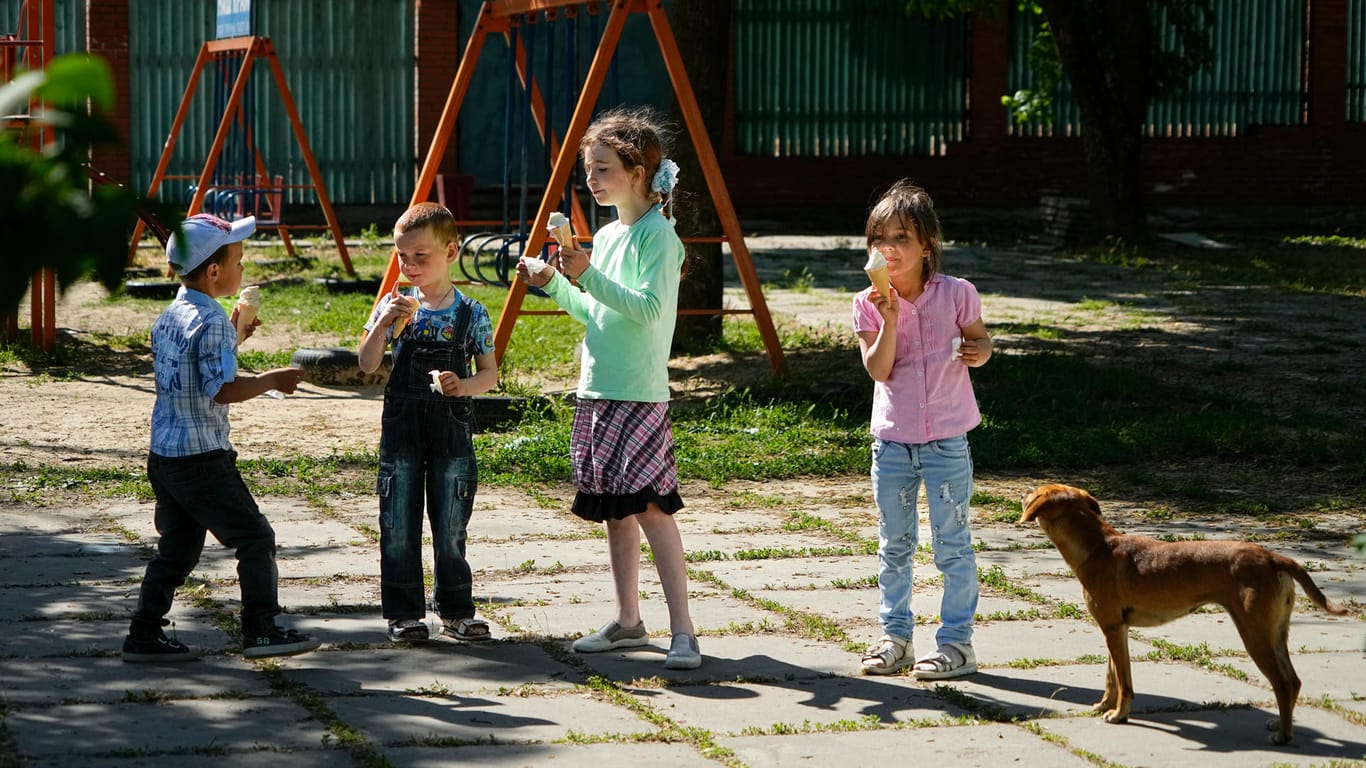 Kinder essen Eis in einem Park in Cherson: Das Foto wurde während einer vom russischen Verteidigungsministerium organisierten Reise aufgenommen.