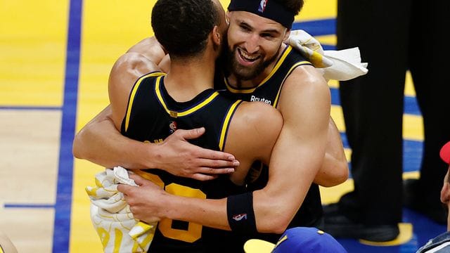 Klay Thompson (r) umarmt Stephen Curry nach dem Sieg der Warriors gegen die Dallas Mavericks.