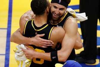 Klay Thompson (r) umarmt Stephen Curry nach dem Sieg der Warriors gegen die Dallas Mavericks.