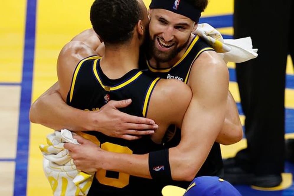 Klay Thompson (r) umarmt Stephen Curry nach dem Sieg der Warriors gegen die Dallas Mavericks.