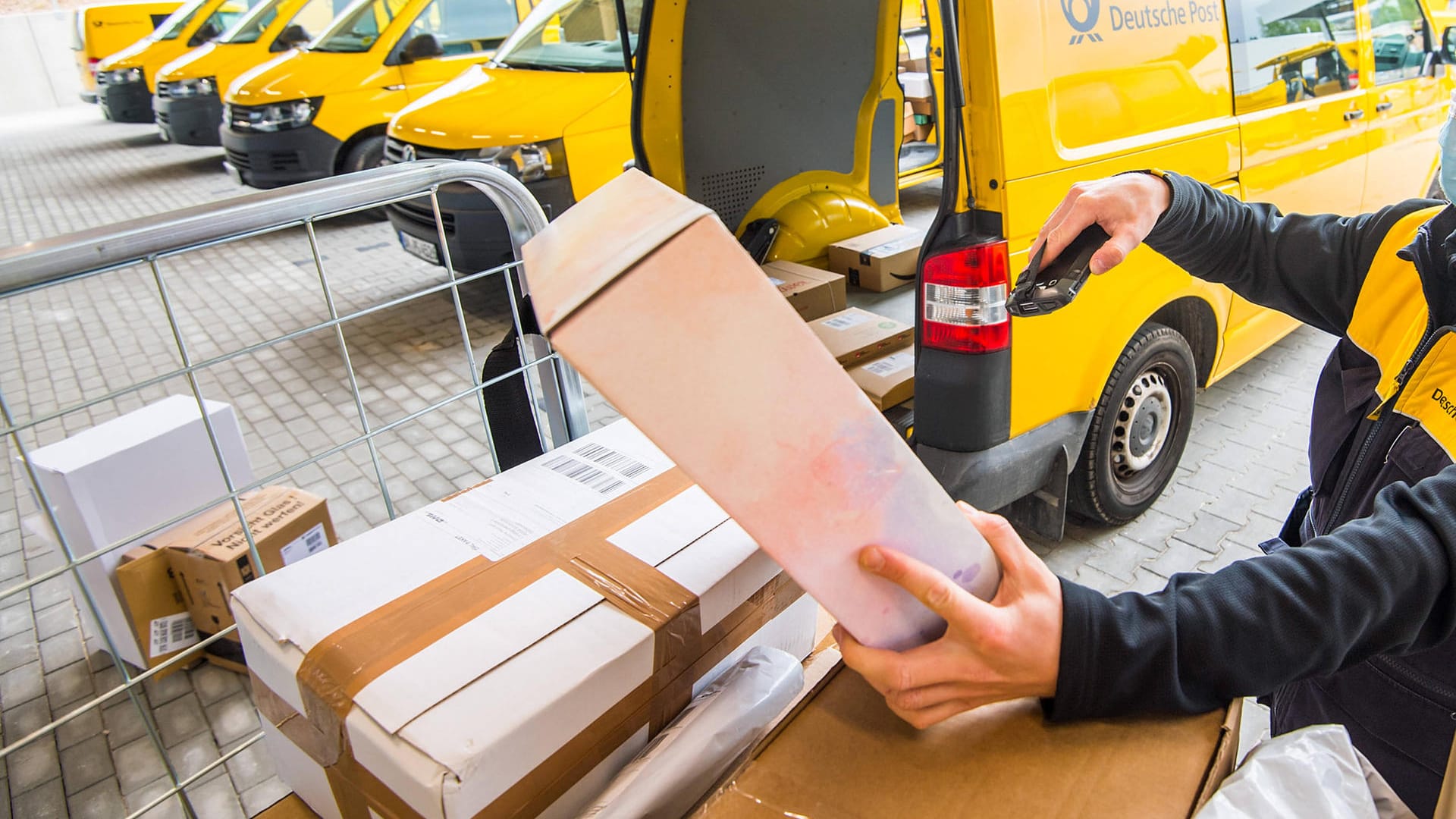 DHL-Mitarbeiter scannt Pakete (Symbolbild): Viele Händler verlangen bisher keine Rücksendegebühren. Entsprechend viel Arbeit haben Lieferdienste mit Retouren.ete mit einem DHL-Mitarbeiter scannt Pakete (Symbolbild): Viele Händler verlangen bisher keine Rücksendegebühren. Entsprechend viel Arbeit haben Lieferdienste mit Retouren.ete mit einem